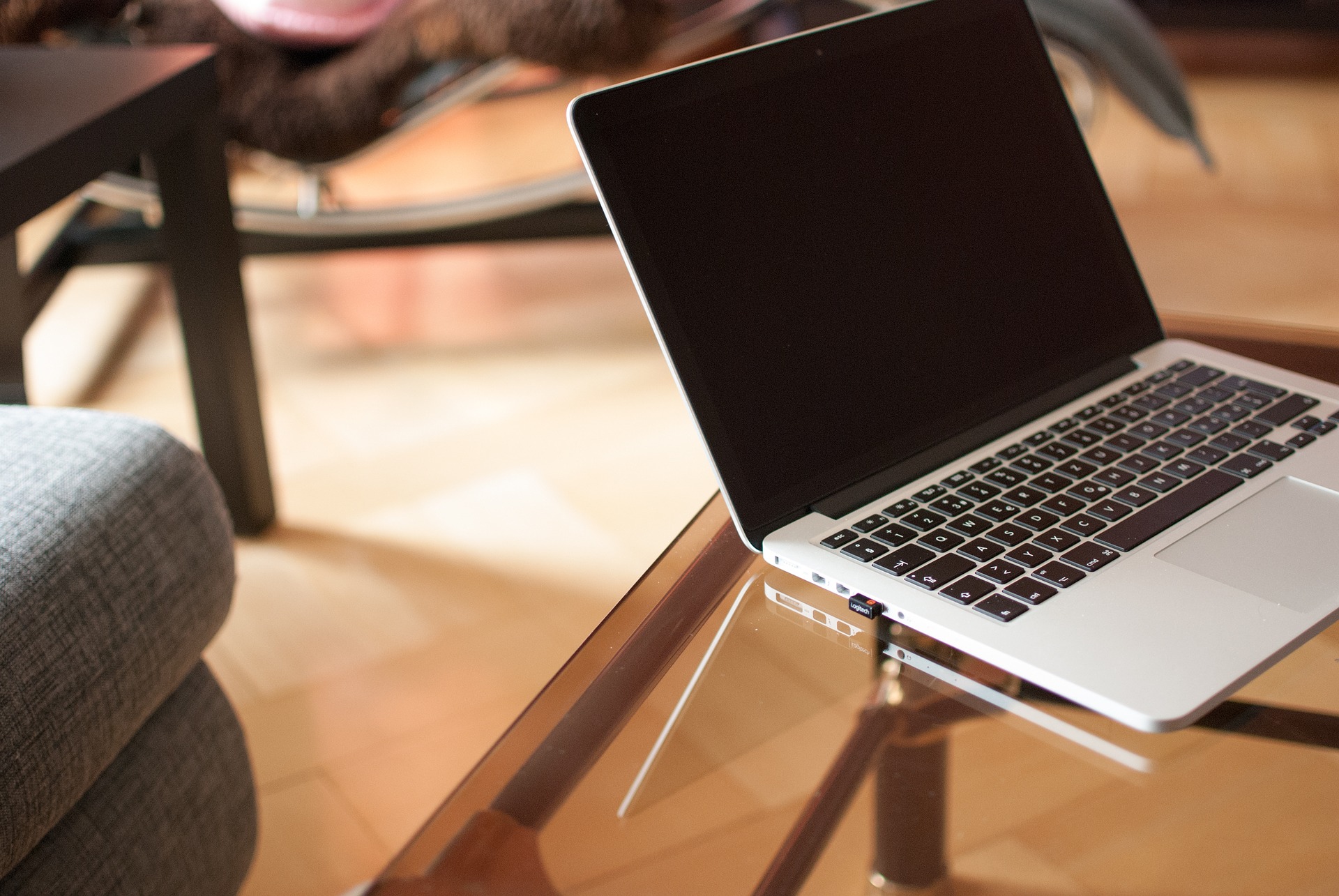laptop leżący na szklanym stole